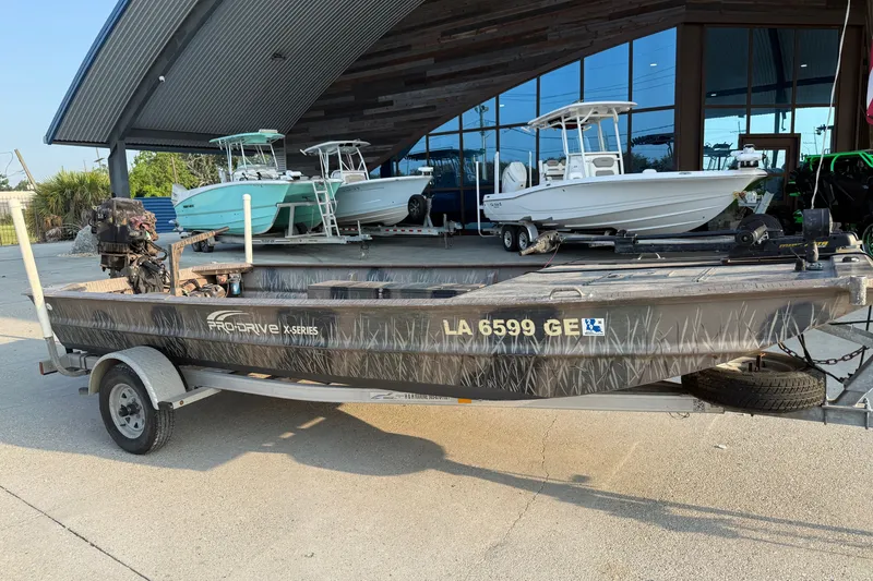 Slide: The Image of 2015 Custom Pro Drive 1754 boat on trailer, parked outside a showroom with other boats. - 3