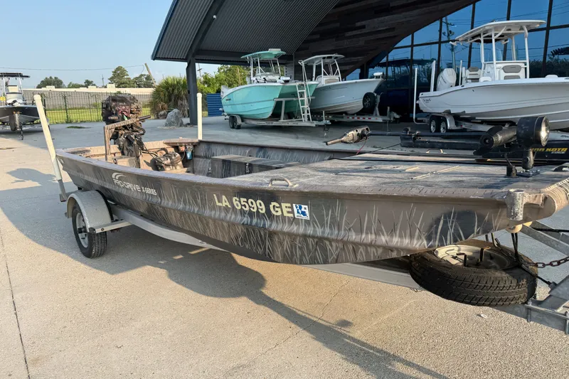 Slide: The Image of 2015 Custom Pro Drive 1754 boat on trailer, parked outdoors near other boats. - 4