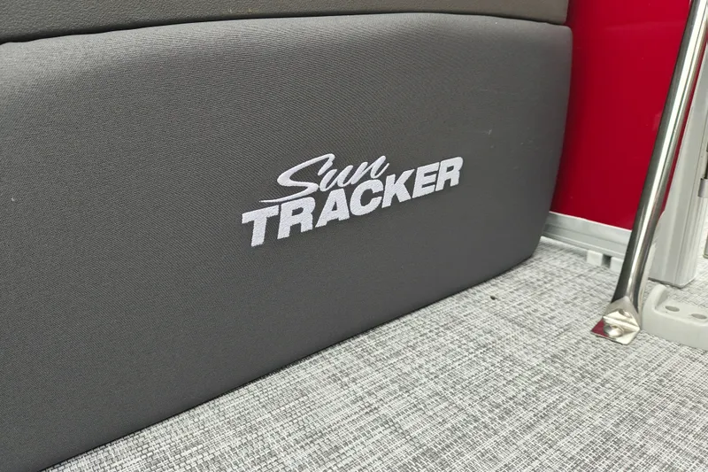 Slide: The Image of 2026 Sun Tracker Party Barge 20 DLX interior detail with logo on gray upholstery. - 26