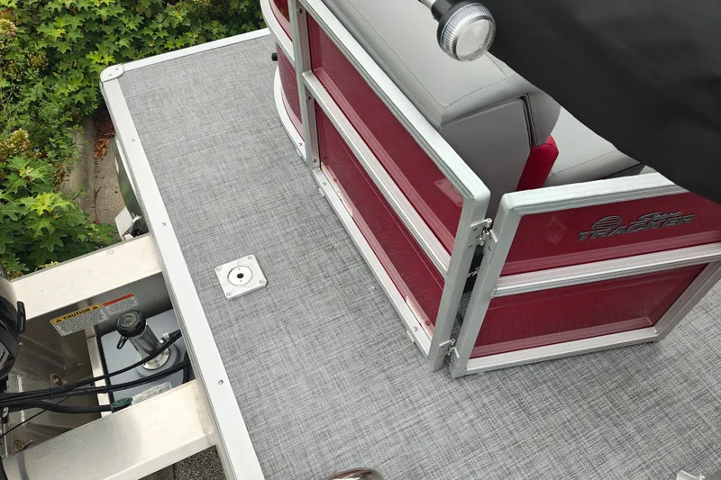 Slide: The Image of 2026 Sun Tracker Party Barge 20 DLX pontoon boat deck with red railing and gray flooring. - 17