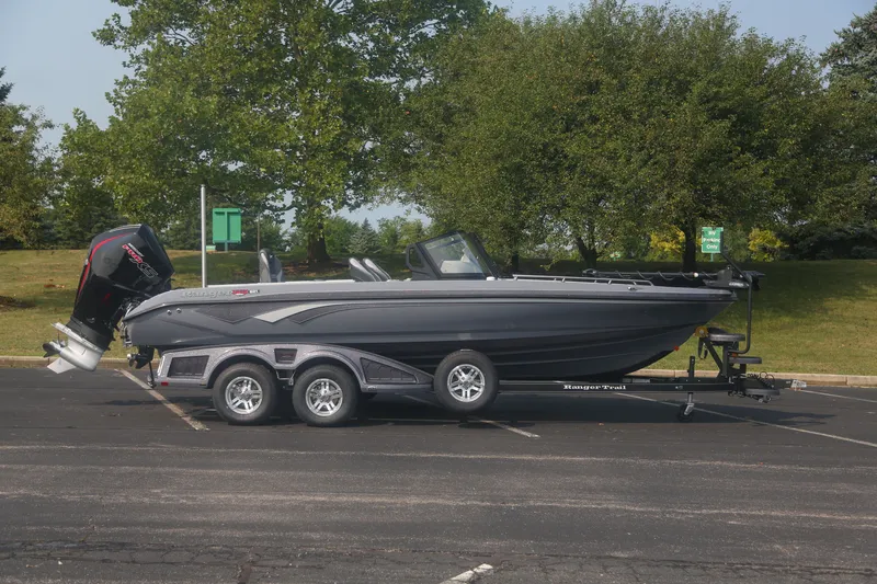 The Image of 2026 Ranger 621FS Pro boat on trailer in parking lot, surrounded by trees. - 0