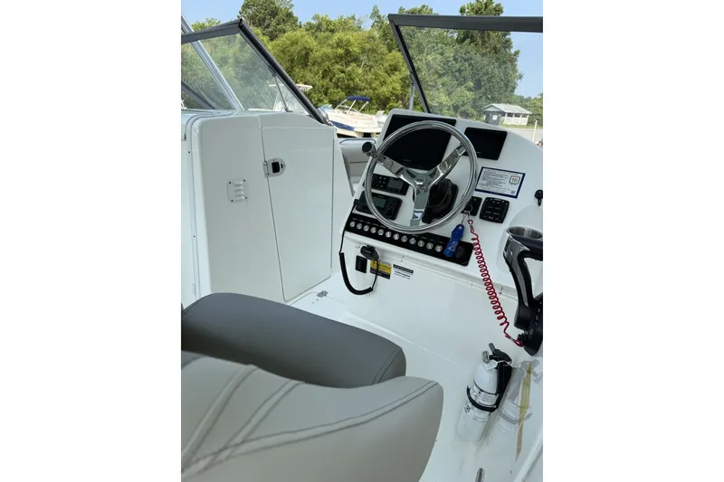 Slide: The Image of 2023 Key West 239 DFS boat cockpit with steering wheel and control panel. - 7