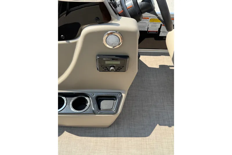 Slide: The Image of 2022 Sun Tracker Bass Buggy 18 DLX dashboard with steering wheel and control panel. - 16