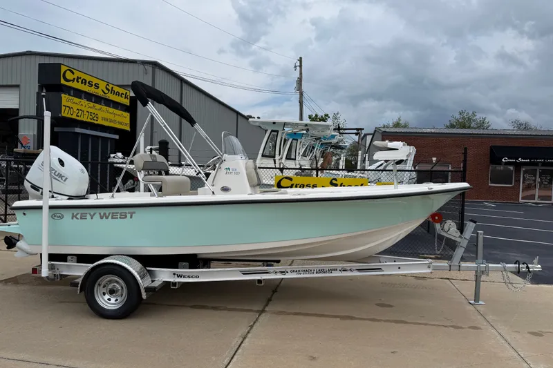 Slide: The Image of 2027 Key West 188 Bay Reef boat on trailer at dealership, overcast sky. - 1