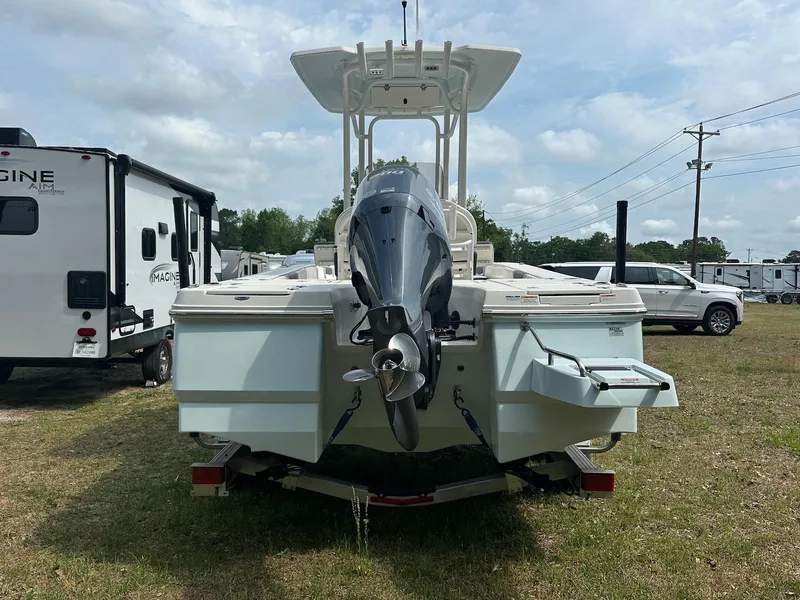 Slide: The Image of 2023 Robalo 226 Cayman boat, rear view, parked on grass with vehicles in background. - 3
