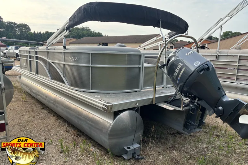 Slide: The Image of 2020 Bennington SX 22 SLX pontoon boat with Yamaha 90 engine, parked outdoors. - 2