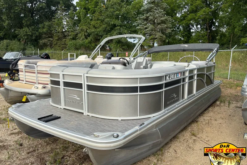 Slide: The Image of 2020 Bennington SX 22 SLX pontoon boat with canopy, parked outdoors near trees. - 1