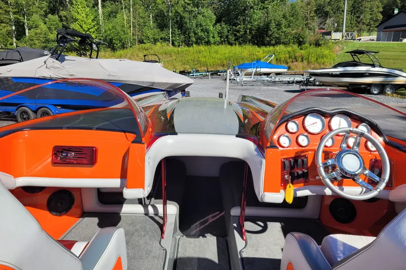 Slide: The Image of Interior view of a 2015 Cobra 260 Venom boat with vibrant orange dashboard. - 9