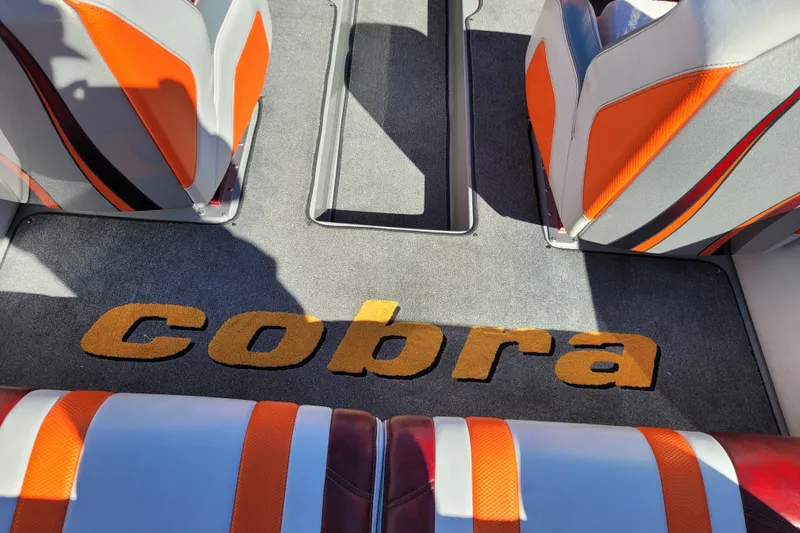 Slide: The Image of 2015 Cobra 260 Venom interior with orange and gray seating, featuring "Cobra" logo on carpet. - 13