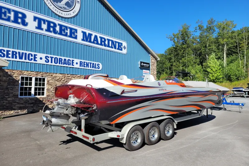 Slide: The Image of 2015 Cobra 260 Venom boat on trailer at Deer Tree Marine, vibrant design, sunny day. - 5