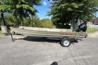 The Image of 2026 Tracker Grizzly 1542 Utility boat on trailer, parked outdoors. - 0