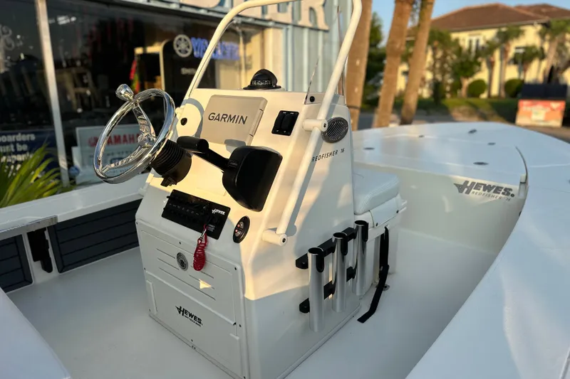 Slide: The Image of 2026 Hewes Redfisher 16 boat console with Garmin navigation system, docked outdoors. - 4