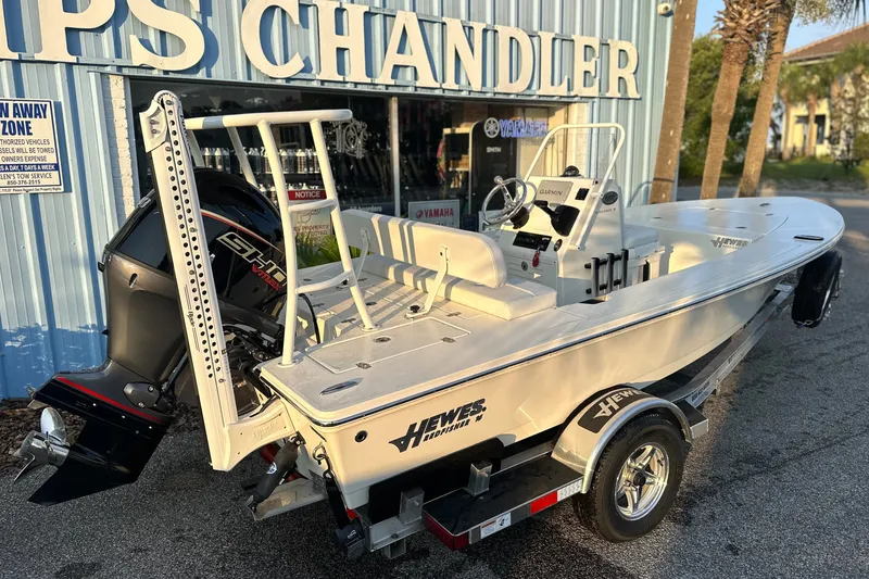Slide: The Image of 2026 Hewes Redfisher 16 boat on trailer outside dealership, featuring Yamaha engine. - 7