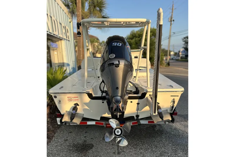 Slide: The Image of 2026 Hewes Redfisher 16 boat with powerful outboard motor, parked outdoors. - 6