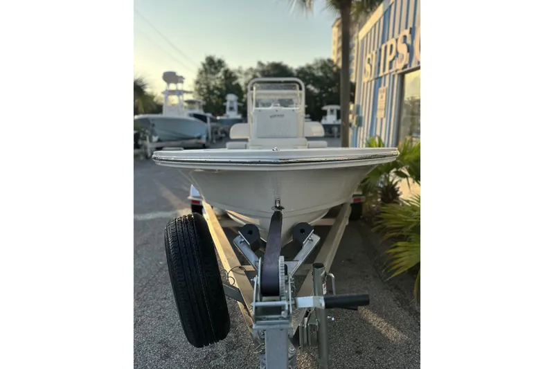 Slide: The Image of 2026 Hewes Redfisher 16 boat on trailer, parked outdoors near a building. - 2