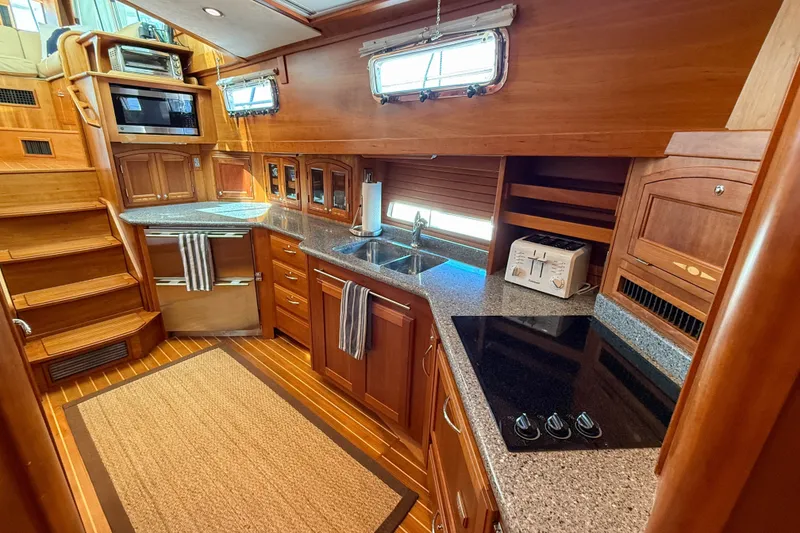 Slide: The Image of Luxurious 2007 Sabre 52 Salon Express yacht kitchen with wood cabinetry and modern appliances. - 27