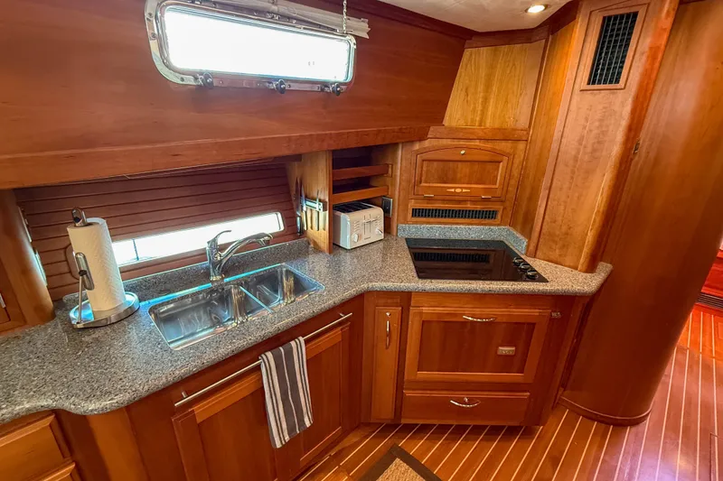 Slide: The Image of Luxurious 2007 Sabre 52 Salon Express yacht kitchen with wood cabinetry and modern appliances. - 26