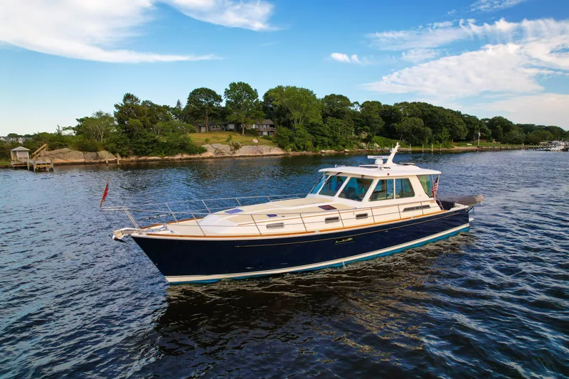 The Image of 2007 Sabre 52 Salon Express yacht cruising on a scenic river with lush greenery. - 1