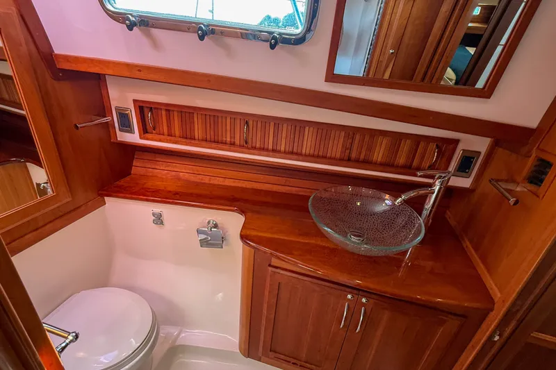 Slide: The Image of Luxurious 2007 Sabre 52 Salon Express yacht bathroom with glass sink and wooden cabinetry. - 35