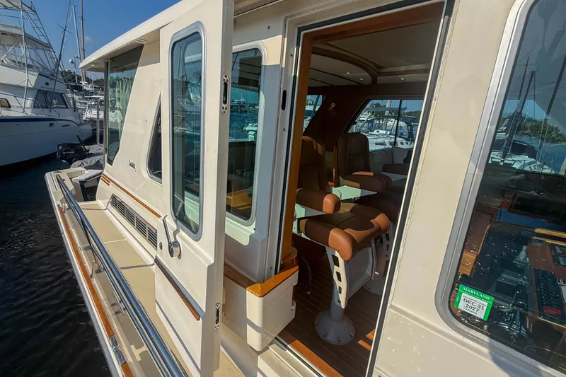 Slide: The Image of 2007 Sabre 52 Salon Express yacht with open cabin door, docked at marina. - 48