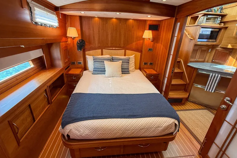 Slide: The Image of Luxurious 2007 Sabre 52 Salon Express yacht bedroom with wood paneling and cozy bedding. - 32