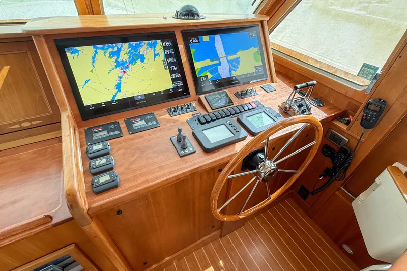 Slide: The Image of 2007 Sabre 52 Salon Express helm with navigation screens and wooden steering wheel. - 21