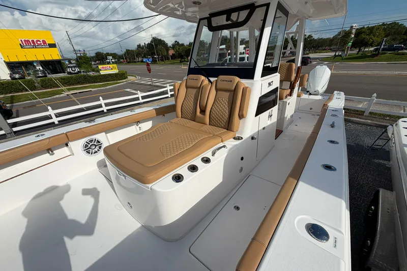 Slide: The Image of 2027 Caymas 29 CT boat with tan seating, docked near a road and store. - 14