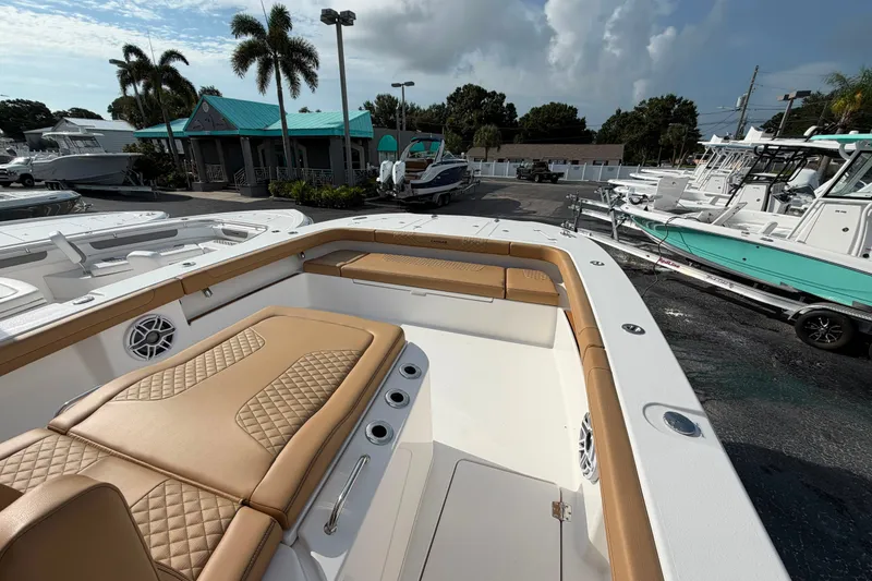 Slide: The Image of 2027 Caymas 29 CT boat with tan seating, docked at a marina with palm trees. - 19