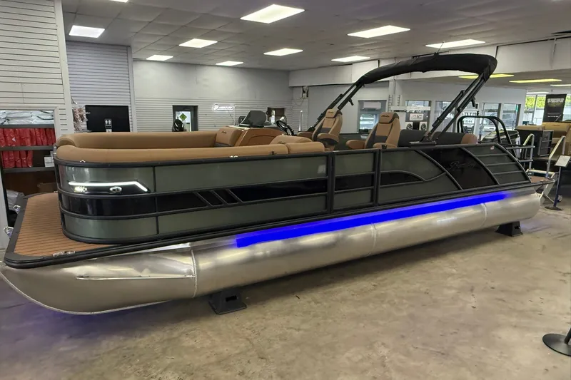 The Image of 2026 Bentley Pontoons Elite 253 Swingback pontoon boat displayed indoors with sleek design and blue lighting. - 0