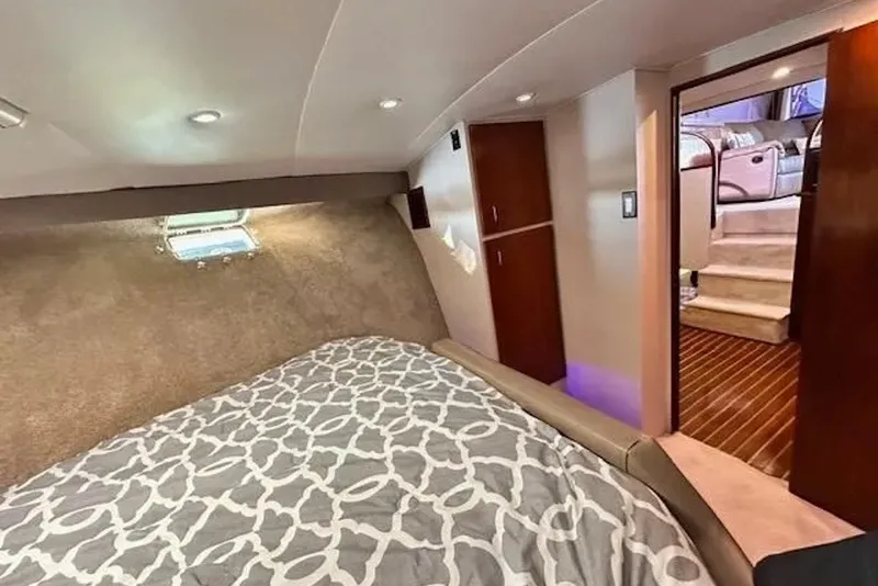 Slide: The Image of Cozy bedroom interior of 1981 Ocean Yachts 42 Super Sport with patterned bedding and soft lighting. - 19
