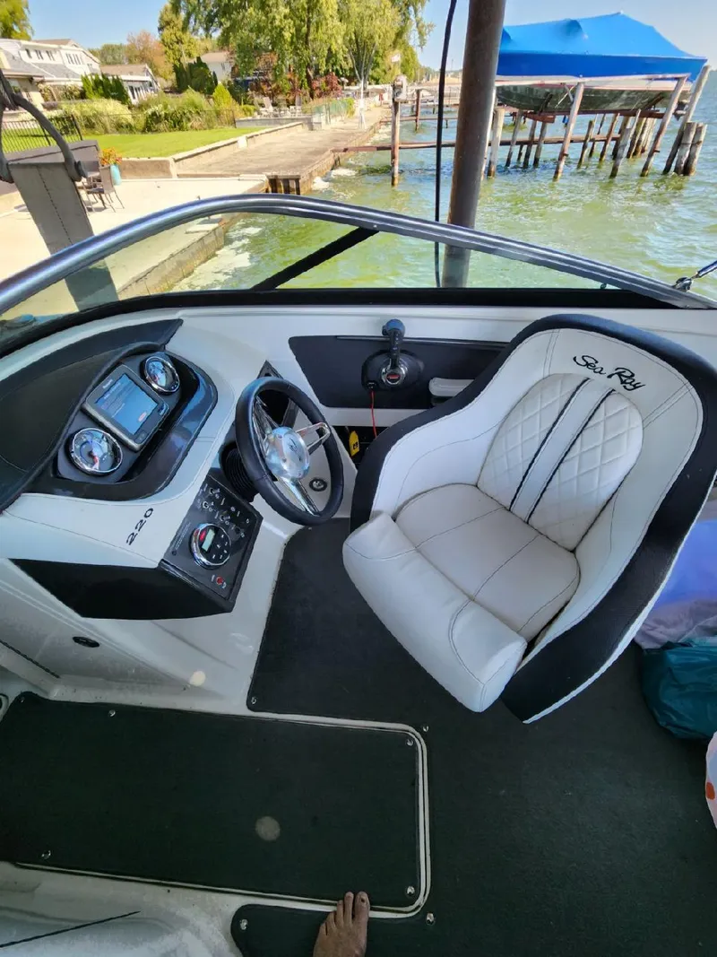 Slide: The Image of The cockpit of a 2015 Sea Ray 220 Sundeck with a sleek white seat and control console. - 29