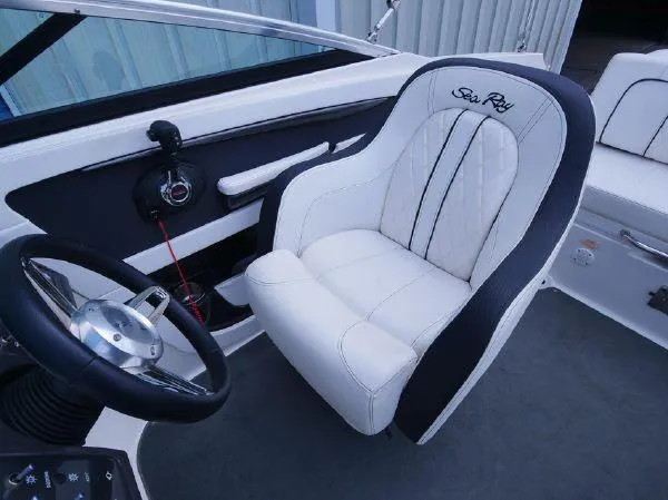 Slide: The Image of The 2015 Sea Ray 220 Sundeck features a sleek white captain's chair with black accents. - 14