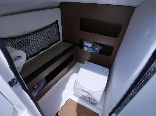 Slide: The Image of Interior of a 2015 Sea Ray 220 Sundeck featuring a toilet and storage space. - 18
