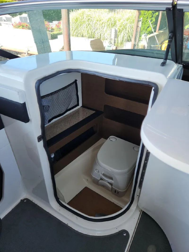 Slide: The Image of The image shows the interior of a 2015 Sea Ray 220 Sundeck with a small toilet. - 31