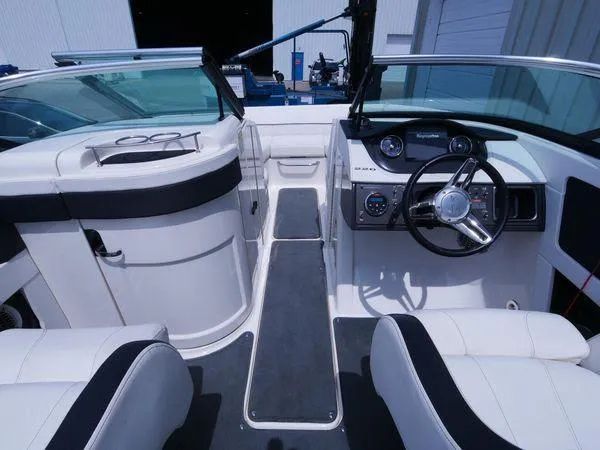 Slide: The Image of Interior view of a 2015 Sea Ray 220 Sundeck with white upholstery and steering console. - 20