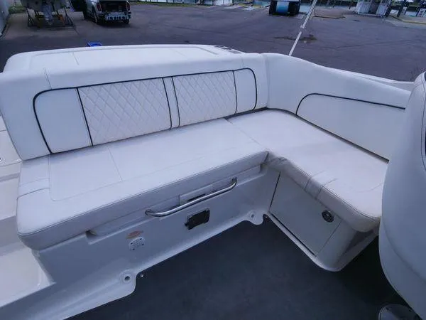 Slide: The Image of The 2015 Sea Ray 220 Sundeck features a spacious, cushioned seating area with elegant stitching. - 13