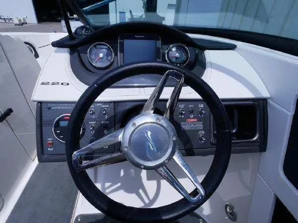 Slide: The Image of The image shows the helm of a 2015 Sea Ray 220 Sundeck boat with modern instruments. - 19