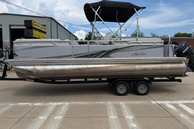Slide: The Image of 2021 Avalon 2280 Venture Quad Lounger pontoon boat on trailer, parked outside. - 1