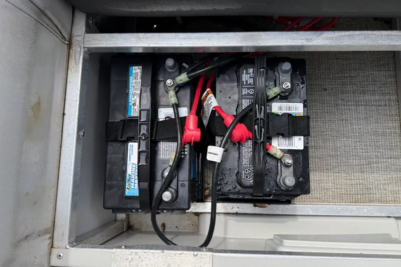 Slide: The Image of Battery compartment of 2021 Avalon 2280 Venture Quad Lounger with dual marine batteries. - 24