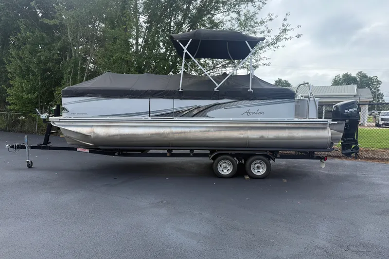 Slide: The Image of 2021 Avalon 2280 Venture Quad Lounger pontoon boat on trailer, parked outdoors. - 6