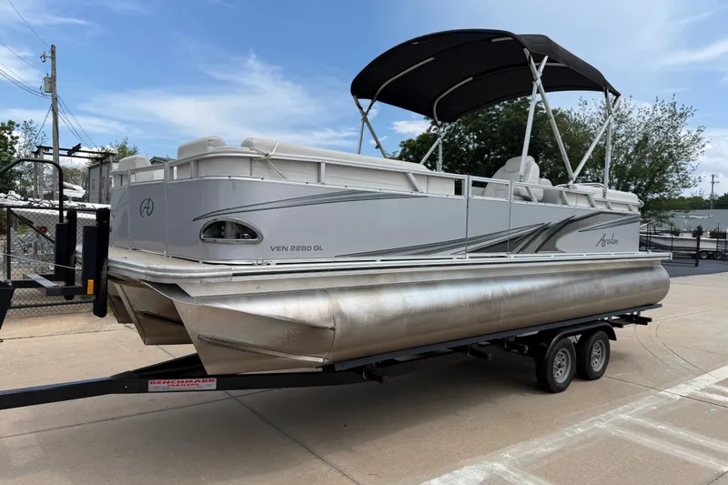 The Image of 2021 Avalon 2280 Venture Quad Lounger pontoon boat on trailer, outdoor setting. - 0