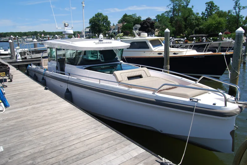 The Image of 2022 Axopar 37 XC Cross Cabin docked at a marina on a sunny day. - 0