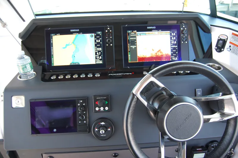 Slide: The Image of Control panel of 2022 Axopar 37 XC Cross Cabin with navigation screens and steering wheel. - 20