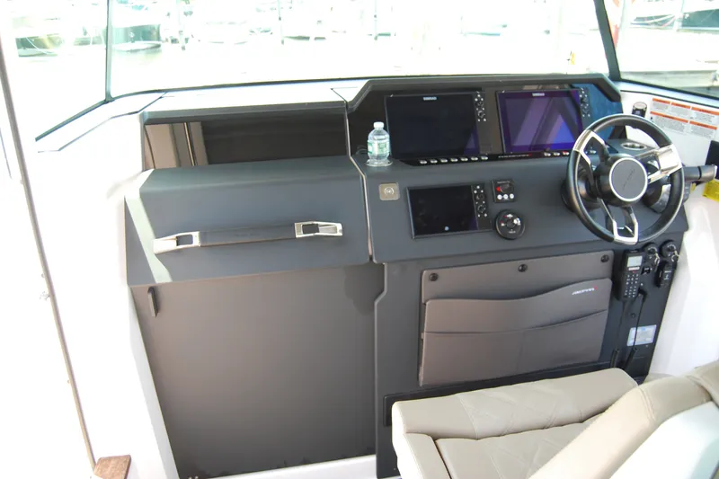 Slide: The Image of 2022 Axopar 37 XC Cross Cabin helm with modern controls and steering wheel. - 24