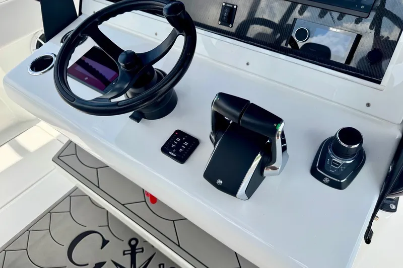 Slide: The Image of 2024 SeaHunter 33 Tournament helm with steering wheel, throttle controls, and navigation system. - 20
