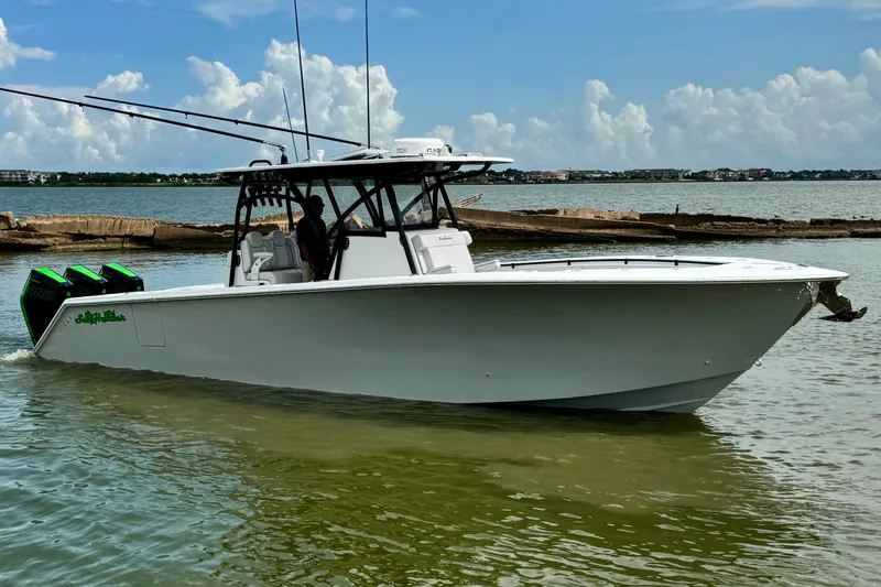 Slide: The Image of 2024 SeaHunter 33 Tournament boat on calm water, featuring triple outboard engines. - 29