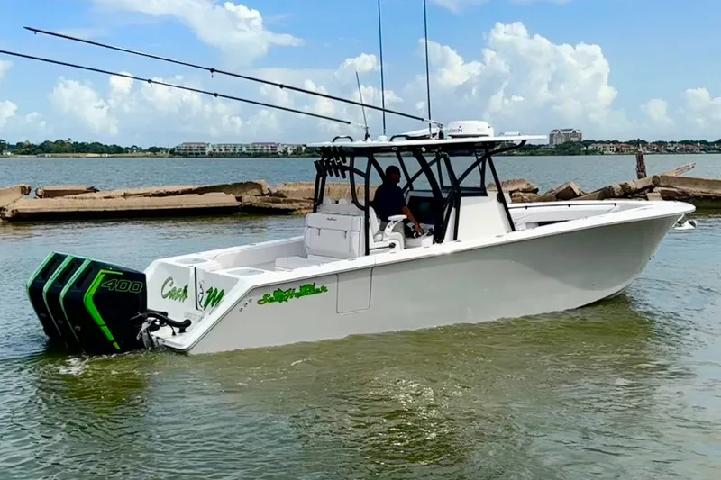 Slide: The Image of 2024 SeaHunter 33 Tournament boat with dual engines on a calm waterway. - 28