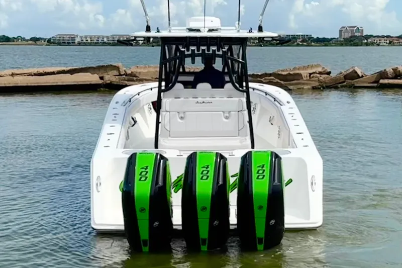Slide: The Image of 2024 SeaHunter 33 Tournament boat with triple 400 horsepower engines in a scenic water setting. - 27