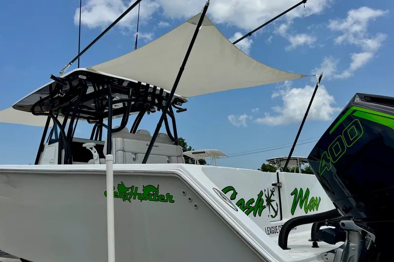 Slide: The Image of 2024 SeaHunter 33 Tournament boat with canopy and powerful 400 engine under blue sky. - 24