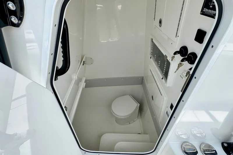 Slide: The Image of 2024 SeaHunter 33 Tournament boat interior with compact marine toilet and control panel. - 15